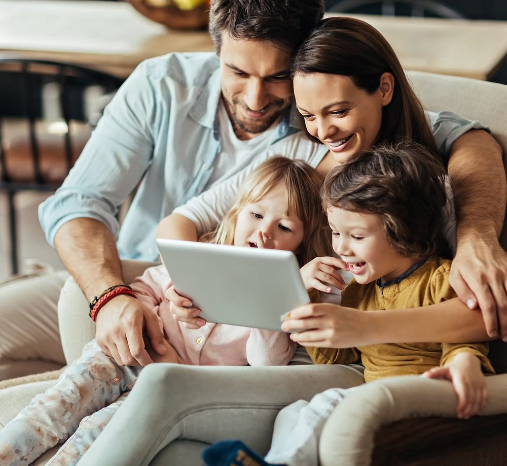 Familie mit zwei Kindern auf dem Sofa